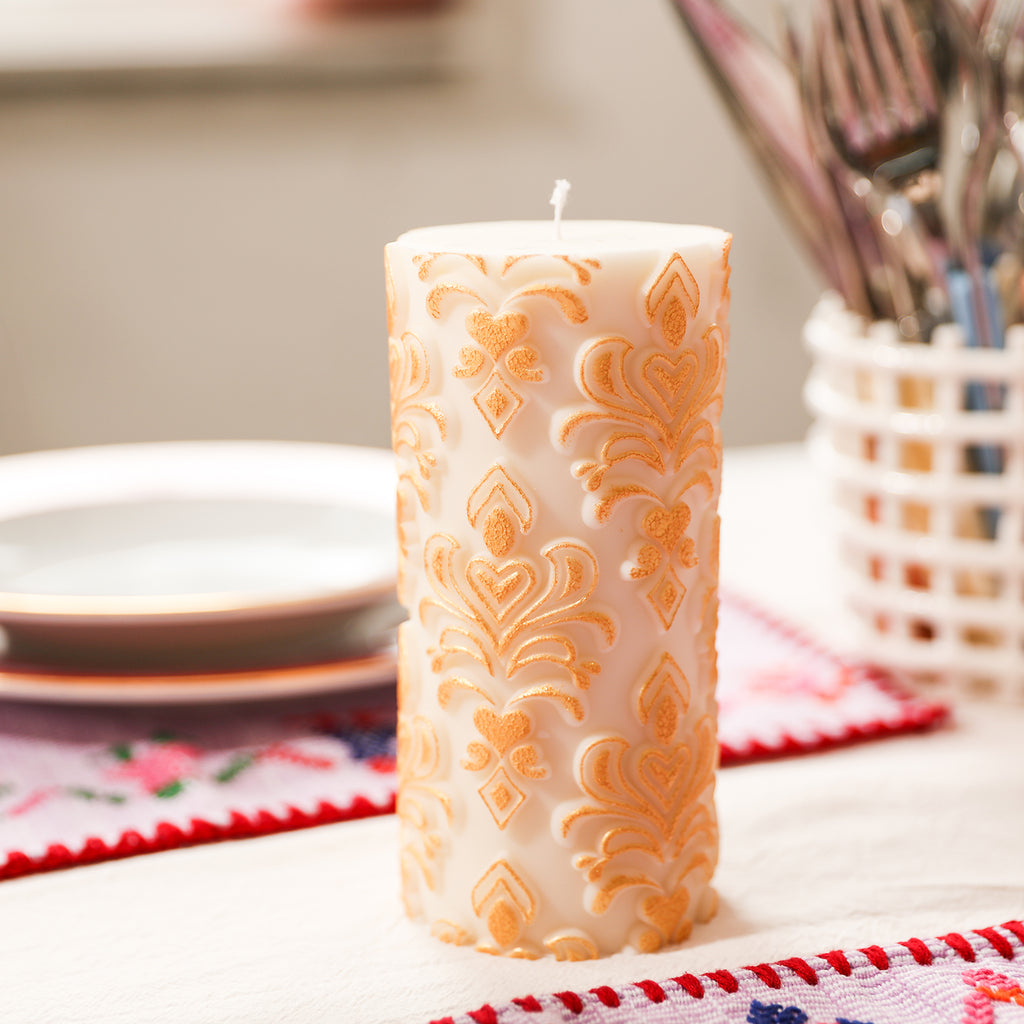 Completed white relief patterned pillar candle, exquisitely detailed.