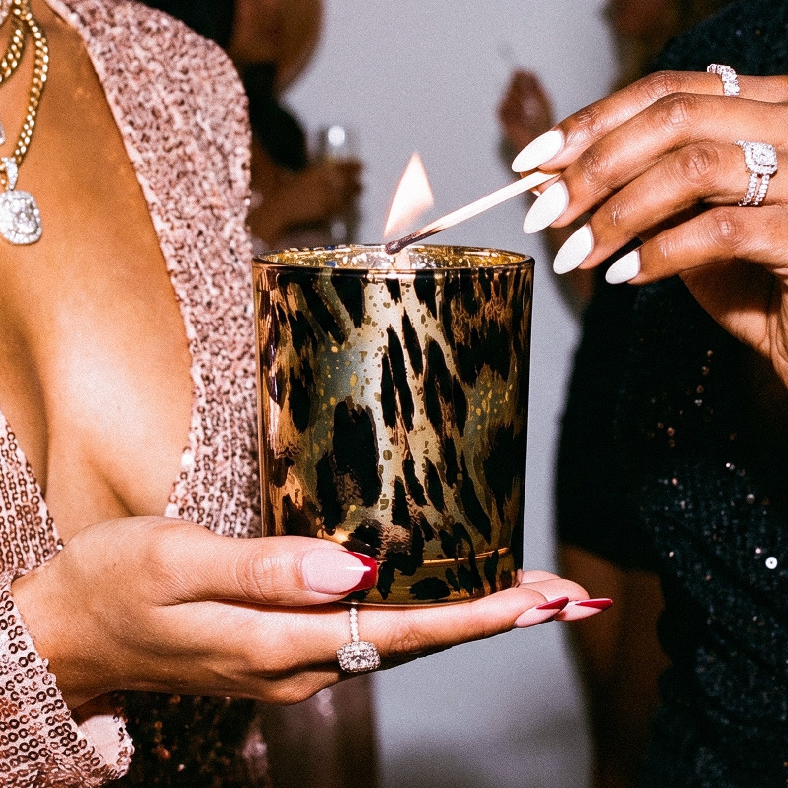 Hand Holding Lit Chic Black Gold Leopard Print Electroplated Glass Candle Jar With Manicured Nails & Diamond Rings - Boowan Nicole