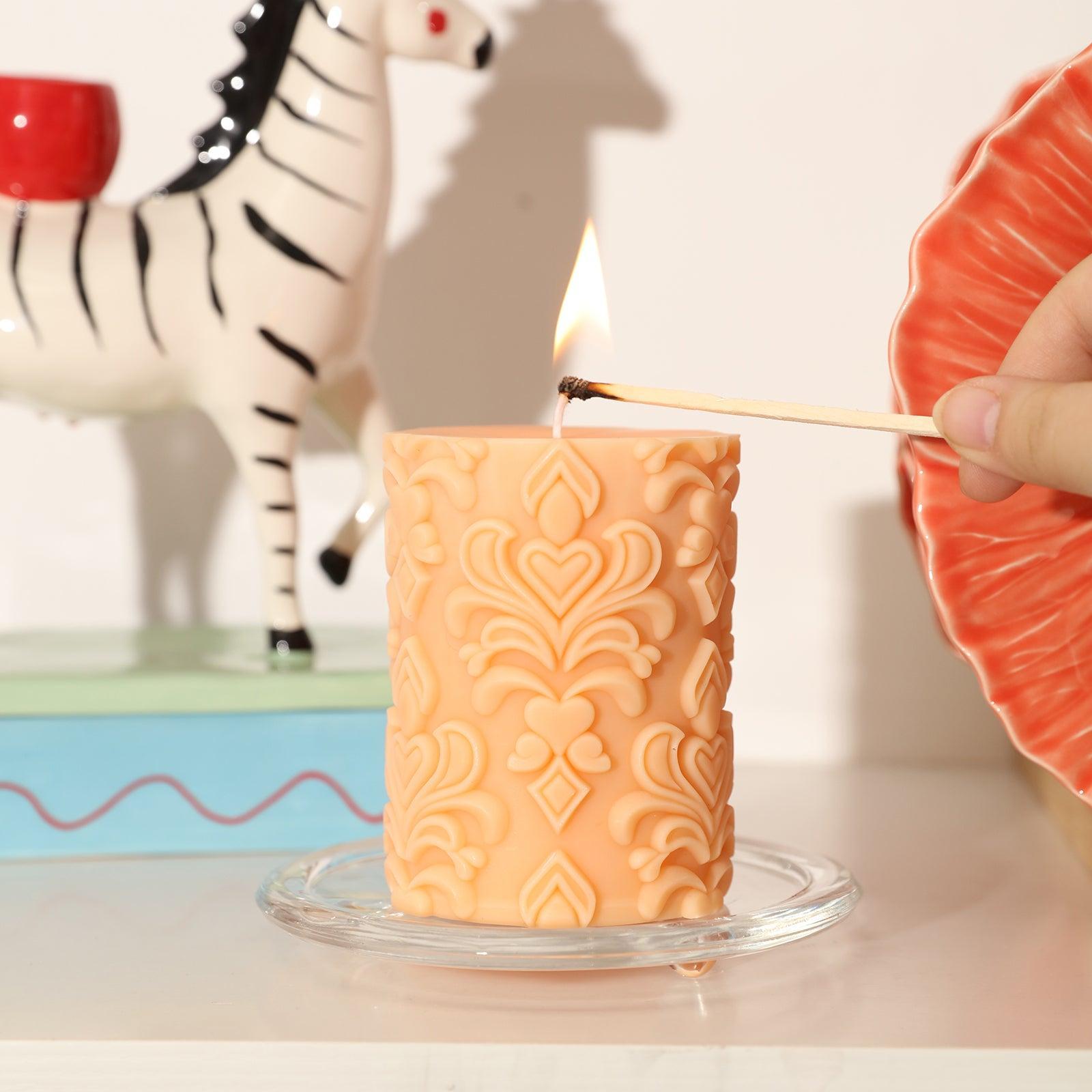  Ignite the warmth with the lit orange relief pattern pillar candle.