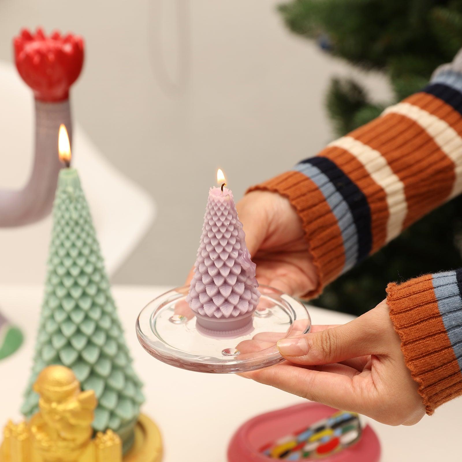 A burning purple Christmas tree candle is placed on the tray in hand - Boowan Nicole