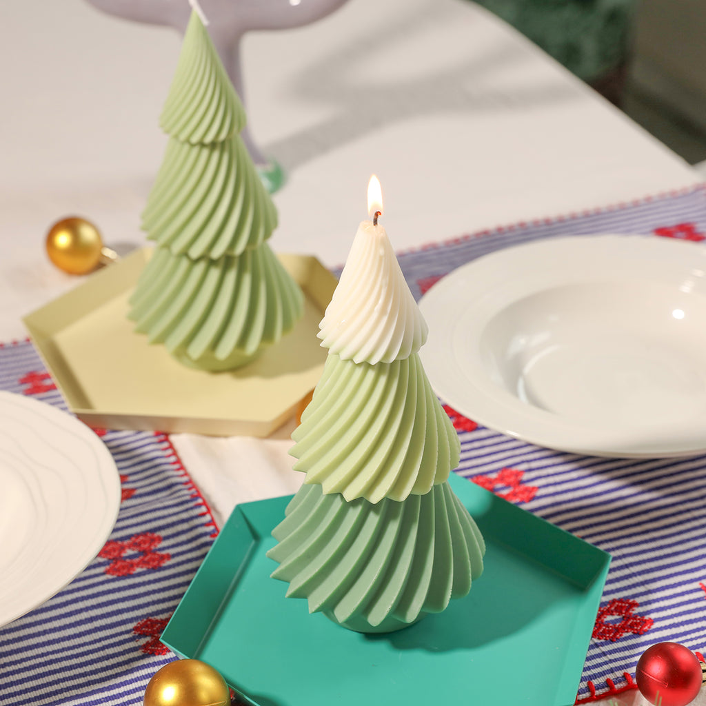 Green and white evergreen Christmas tree candles lit in green plastic tray on dining table - Boowan Nicole