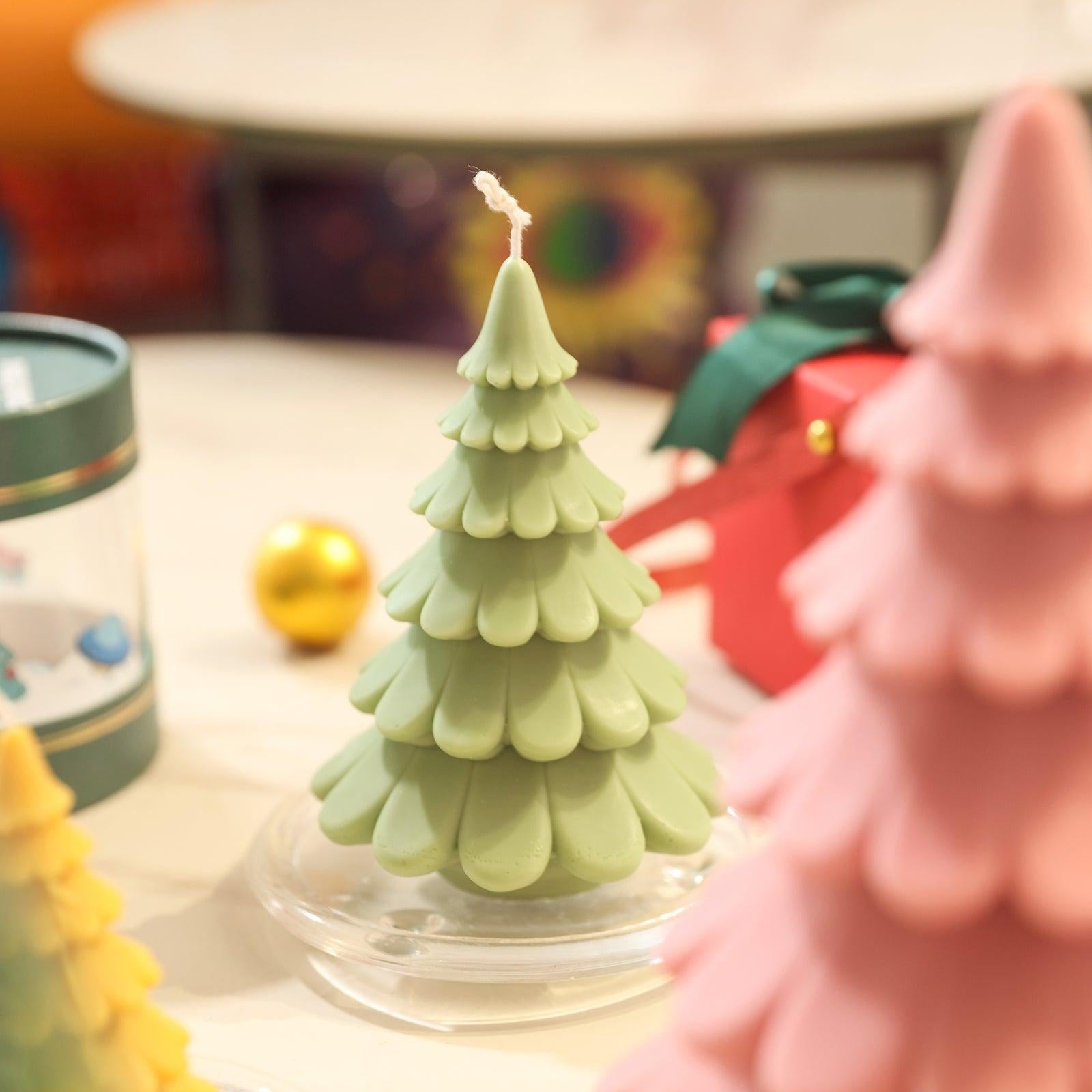 Christmas tree candles in a crystal tray on the table, next to various Christmas gifts, designed by Boowan Nicole.