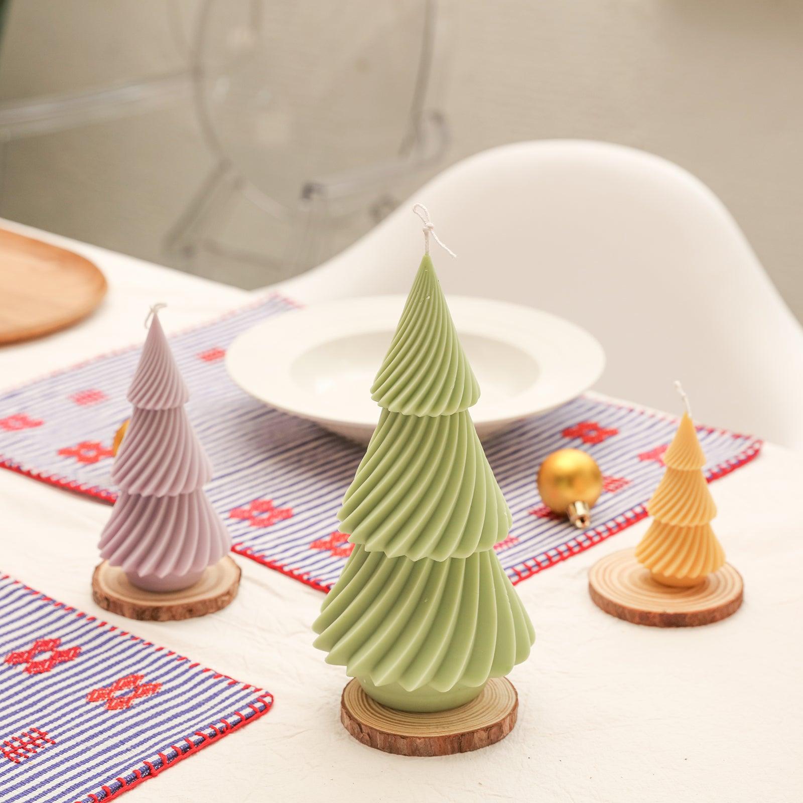 Evergreen Christmas tree candles in three different colors, large, medium and small, placed on the wooden tray on the dining table--Boowan Nicole