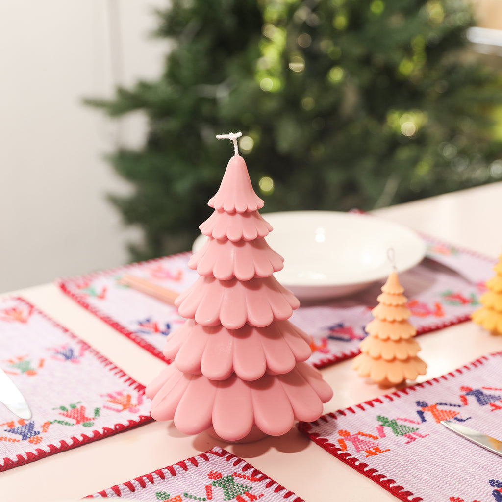 Pink tiered Christmas tree candles placed on the dining table, designed by Boowan Nicole.