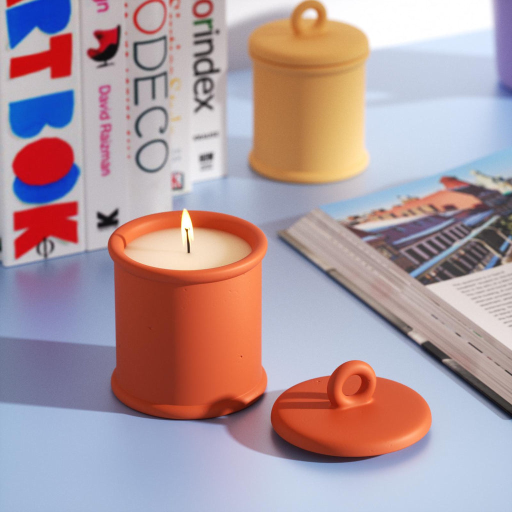 A candle is burning slowly in the Cylinder Short Candle Jar with a ring candle lid nearby -Boowan Nicole
