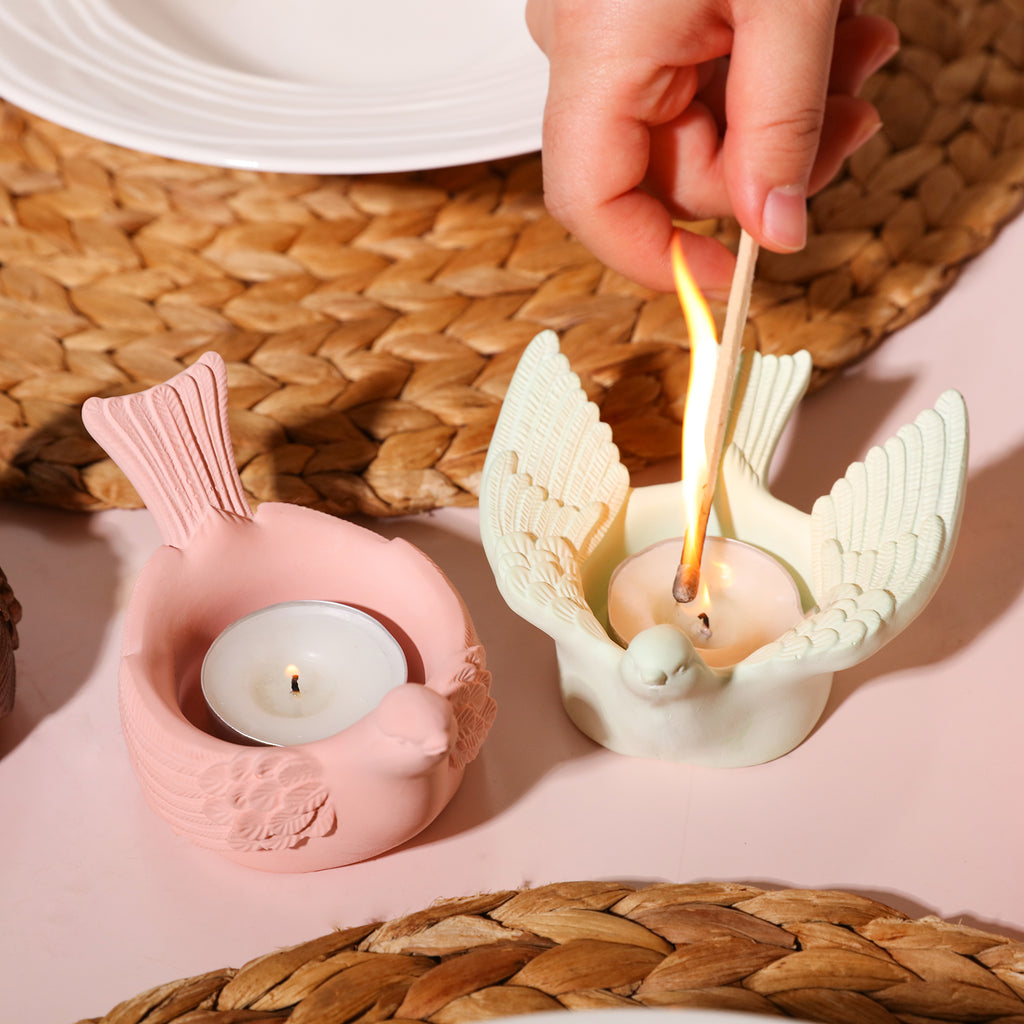 Sequential ignition of candles in bird-shaped tea light holders—one with open wings, the other with closed wings, radiating a sense of happiness.