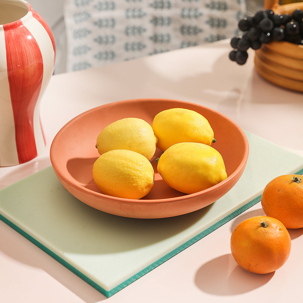 Four lemons are placed in a large round tray, which expands the different usage scenarios of the tray.