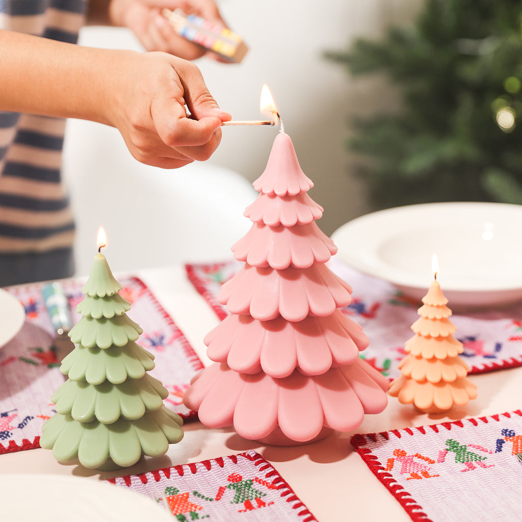 Add a festive touch by lighting the large pink tiered Christmas tree candles on your dining table, designed by Boowan Nicole.