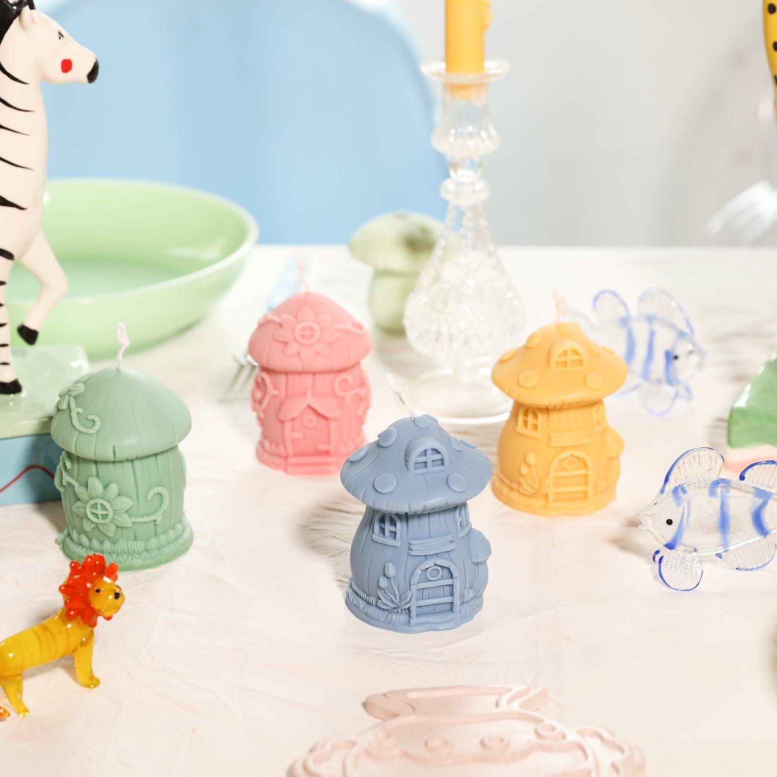 Mushroom House candles in four different designs, green, pink, blue and yellow, designed by Boowan Nicole.