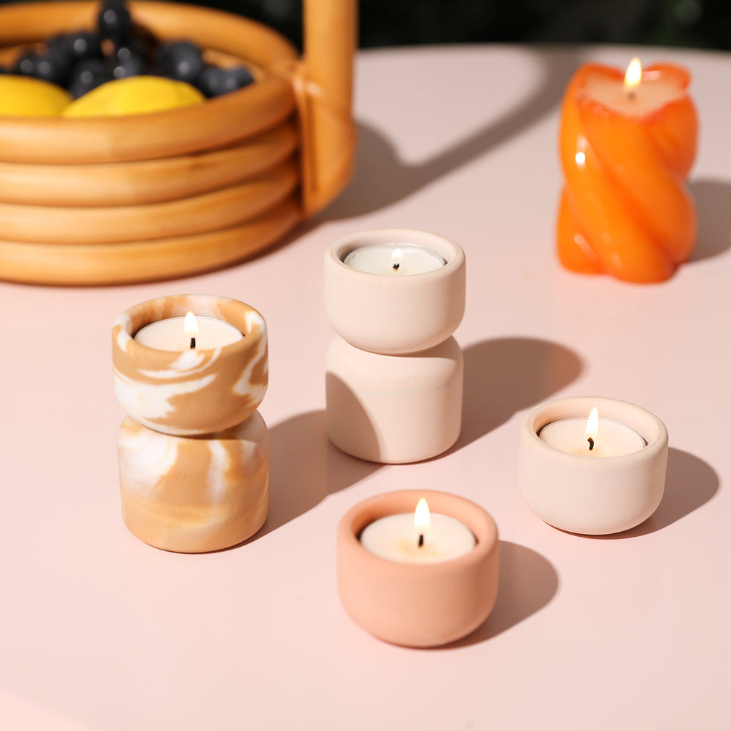 Two single and two stacked candle holders, candles glowing brightly.