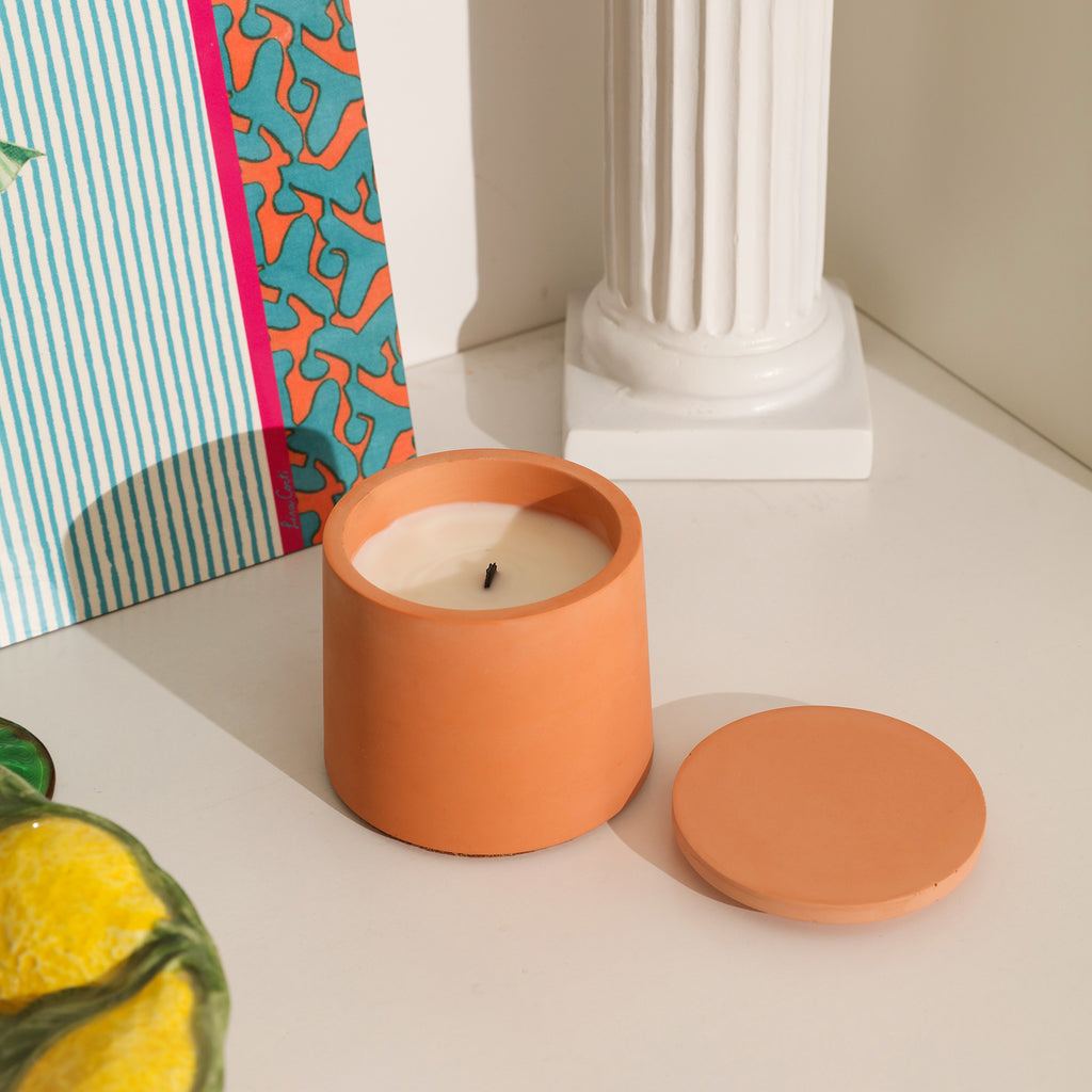Boowannicole's orange candle jar, with the lid nearby, captures a tranquil moment as the flame has extinguished.