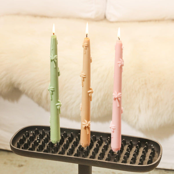 Lighted palm tree relief taper candle in candle holder.