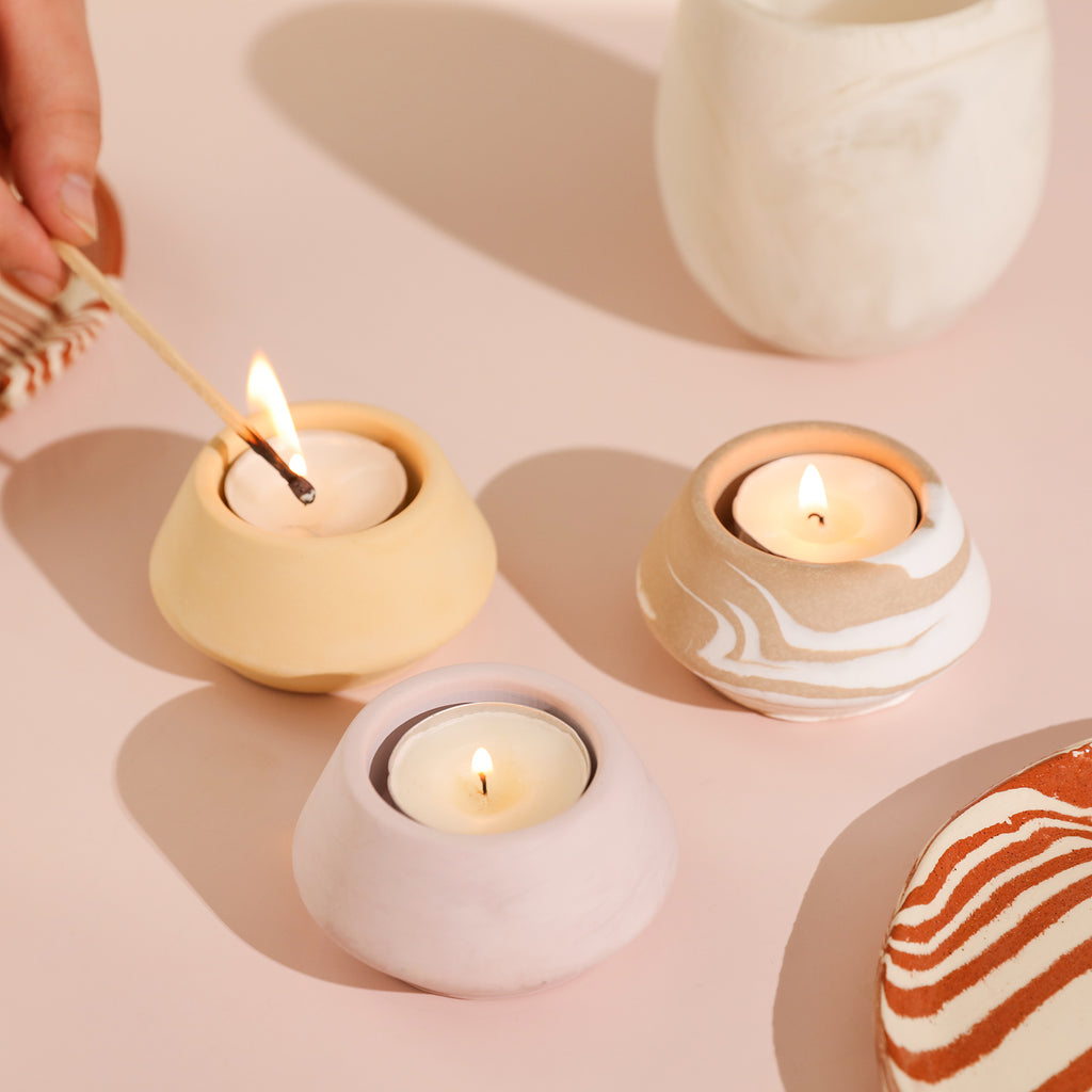 Lit candles on three holders, creating a radiant scene on the table.