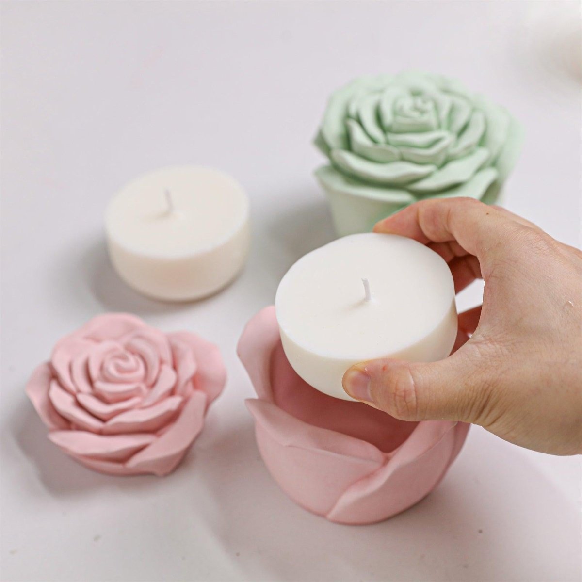 Placing a refill candle into the pink rose-shaped candle jar - Boowan Nicole