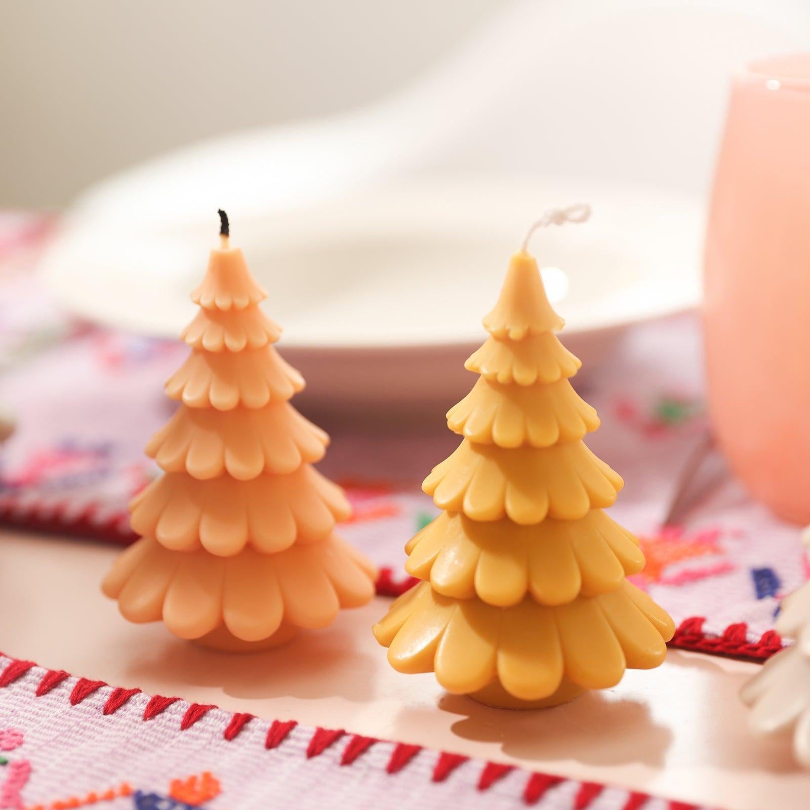Yellow 4-inch Christmas tree candle placed in hand display, designed by Boowan Nicole.