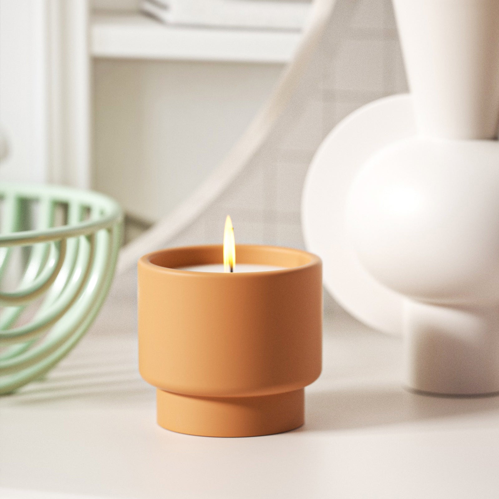Bowl-shaped candle jar is burning on the table
