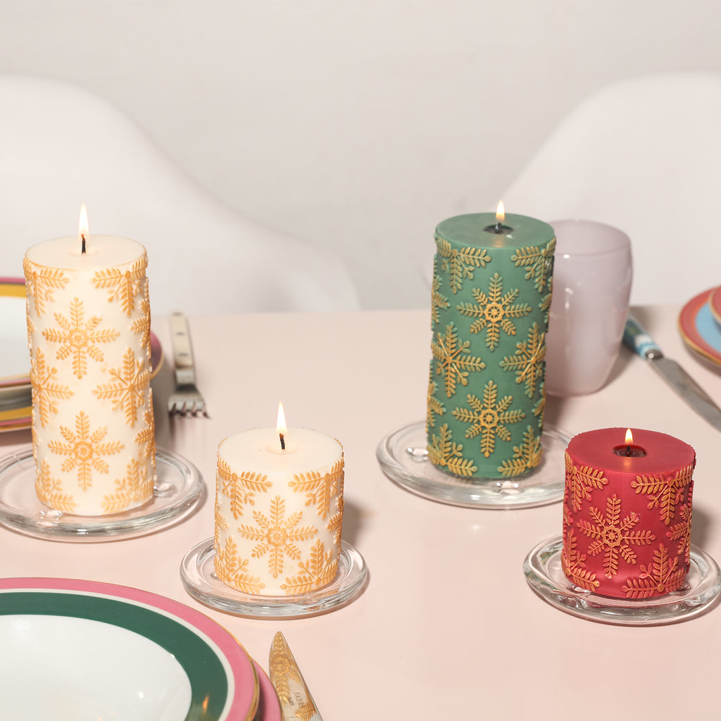 There are white long and short snowflake relief candles, green long snowflake relief candles, and red short snowflake relief candles placed in four crystal trays on the dining table.
