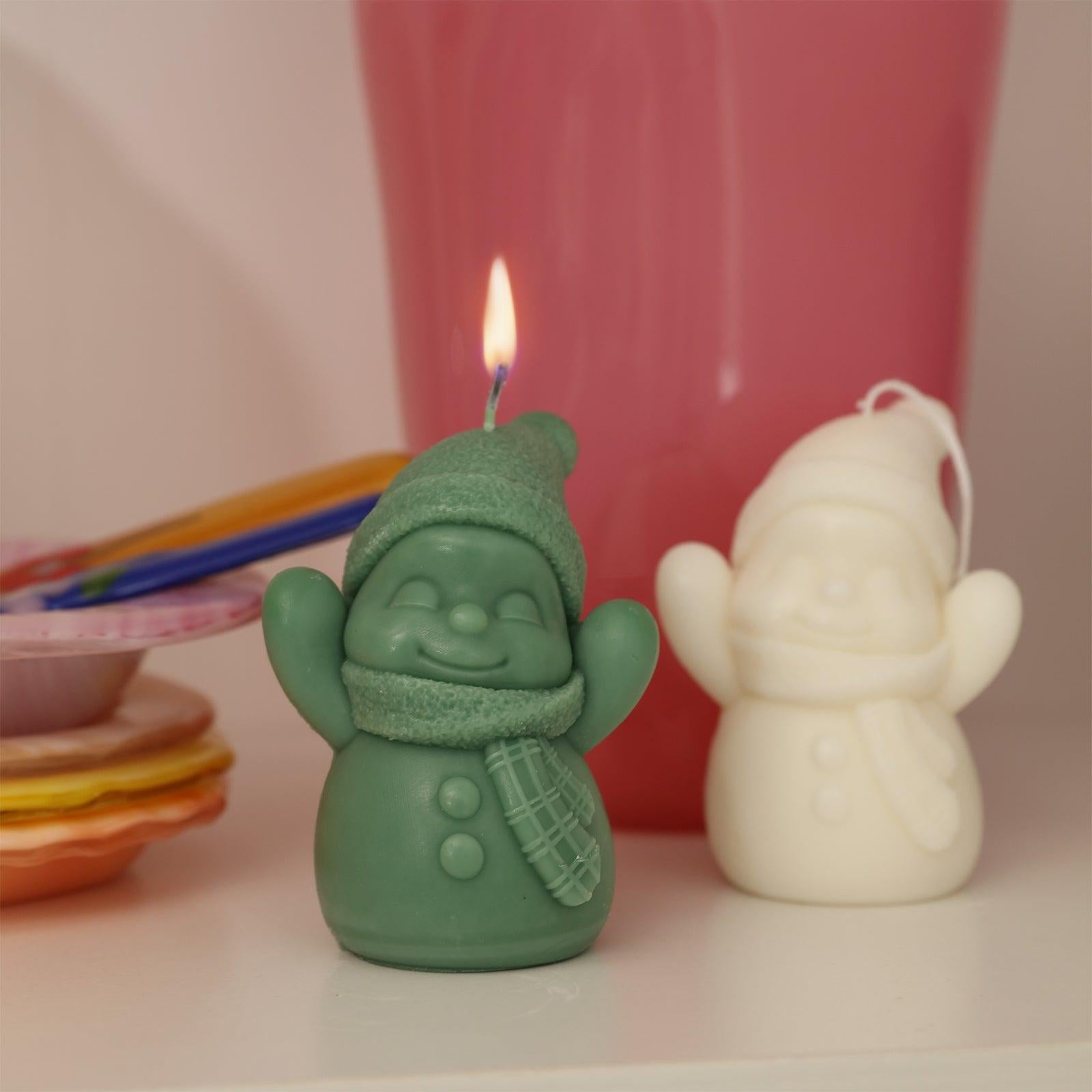 Green Cheering Snowy Friends Candle being lit on the table - Boowan Nicole