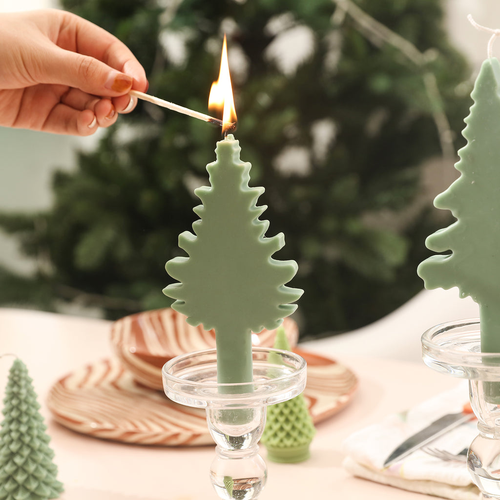 Light green Christmas tree candles in crystal candlesticks on the dining table.