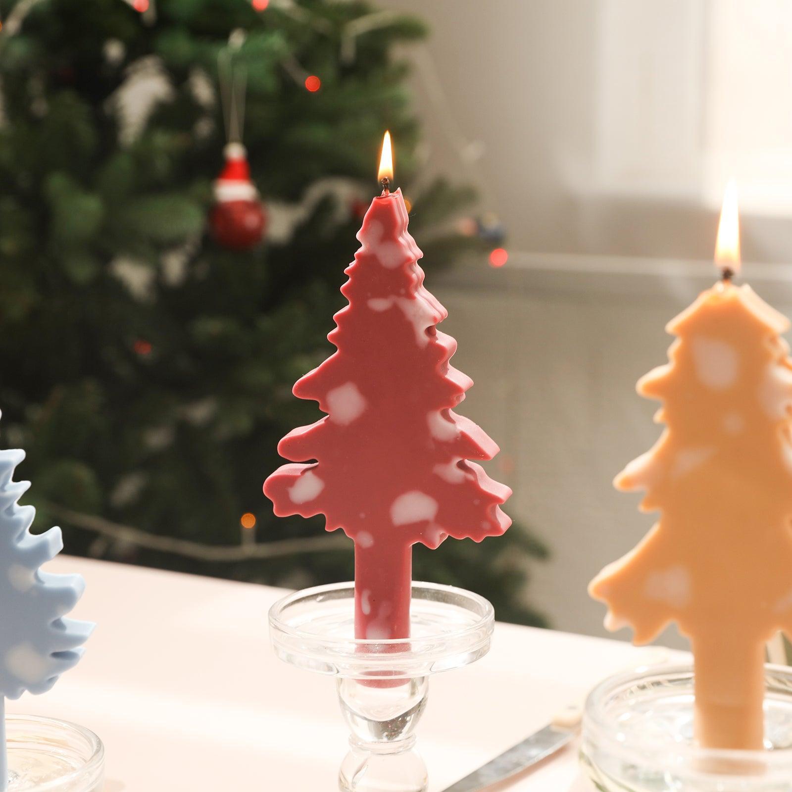 Red Christmas candle in crystal candle holder with white accents on table.