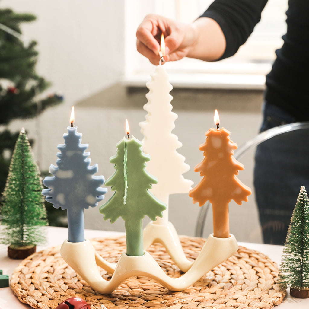 Four Christmas tree-shaped tapered candles are placed on the candle holders to enhance the Christmas atmosphere.