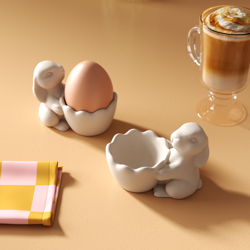 Two egg cups placed next to a cup of coffee