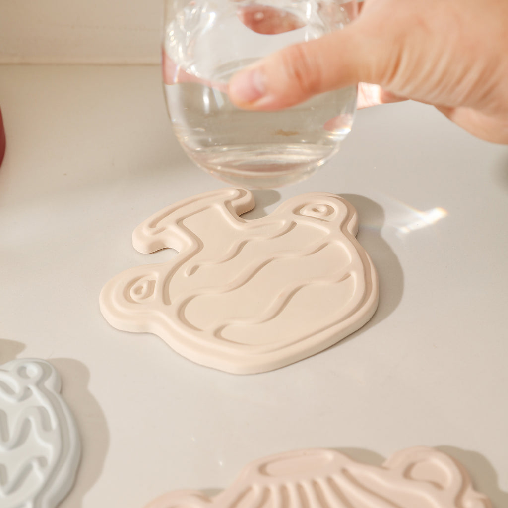 Place the water glass on the pink honey jar-shaped coaster, designed by Boowan Nicole.