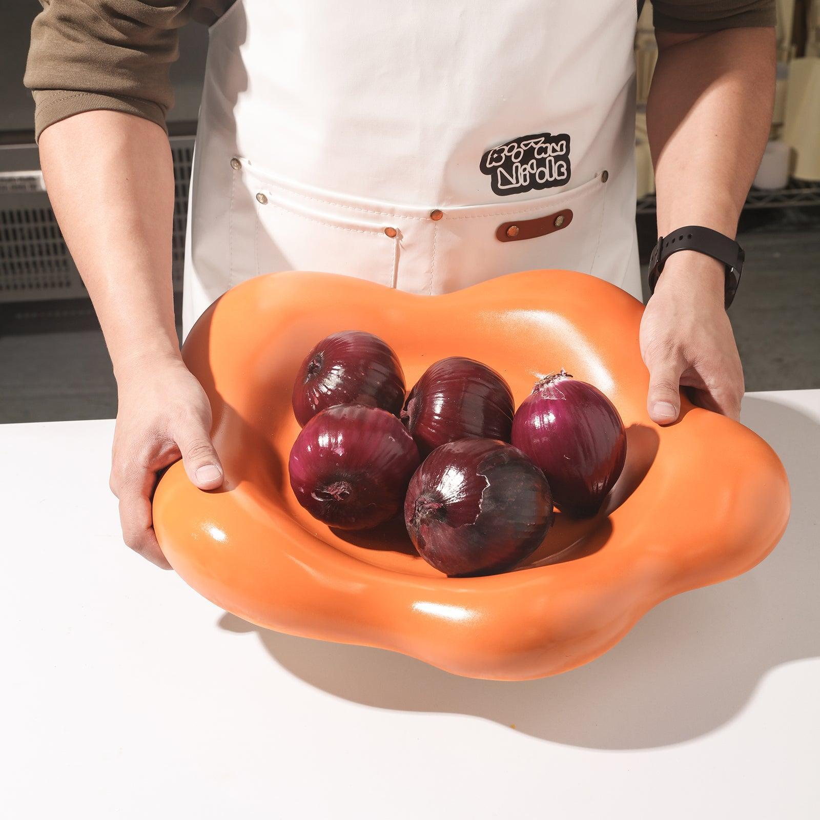 Onions are held on a large flower-shaped tray held by the hand.