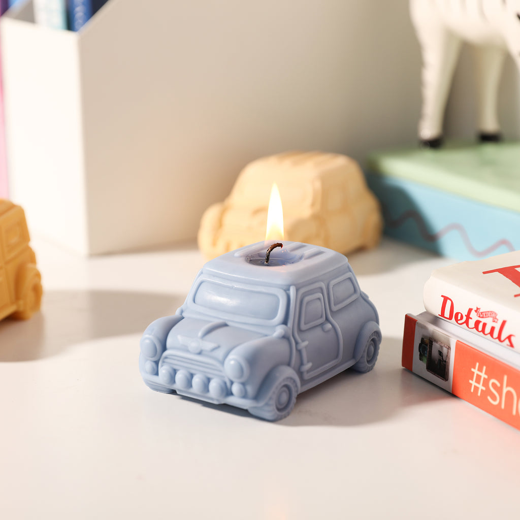 The blue retro car-shaped candle is slowly burning on the desk, designed by Boowan Nicole.