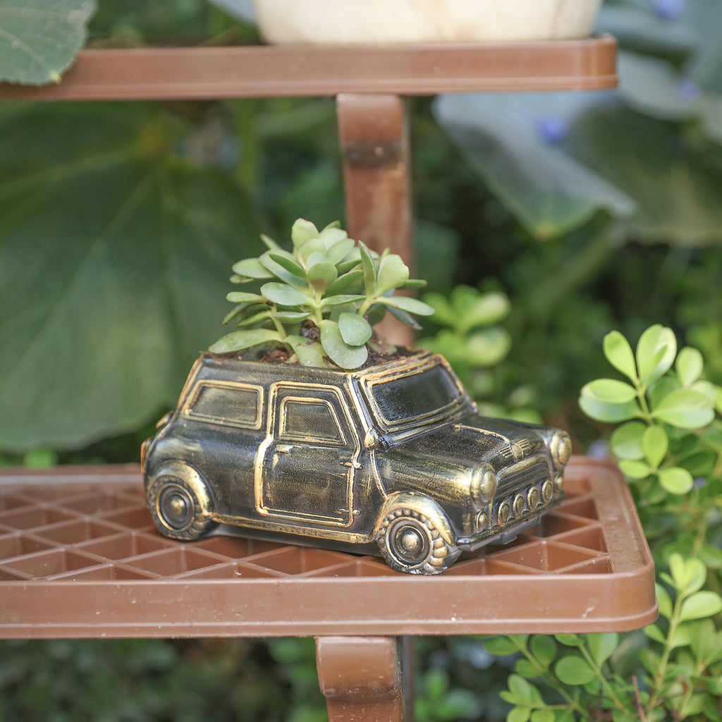Black and gold retro car-shaped plant pots with plants placed on outdoor flower stands-Boowan Nicole