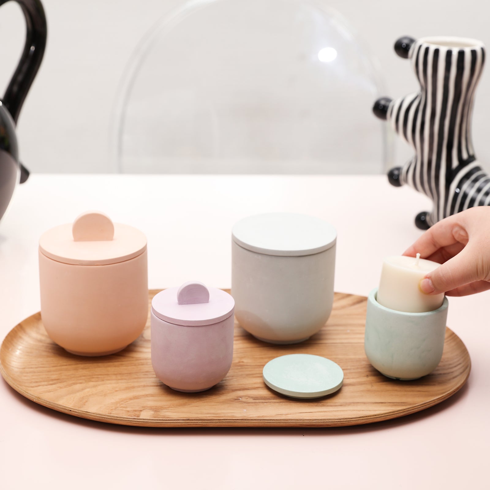 Candle jars are displayed in trays on the table, with refills placed in one of them.