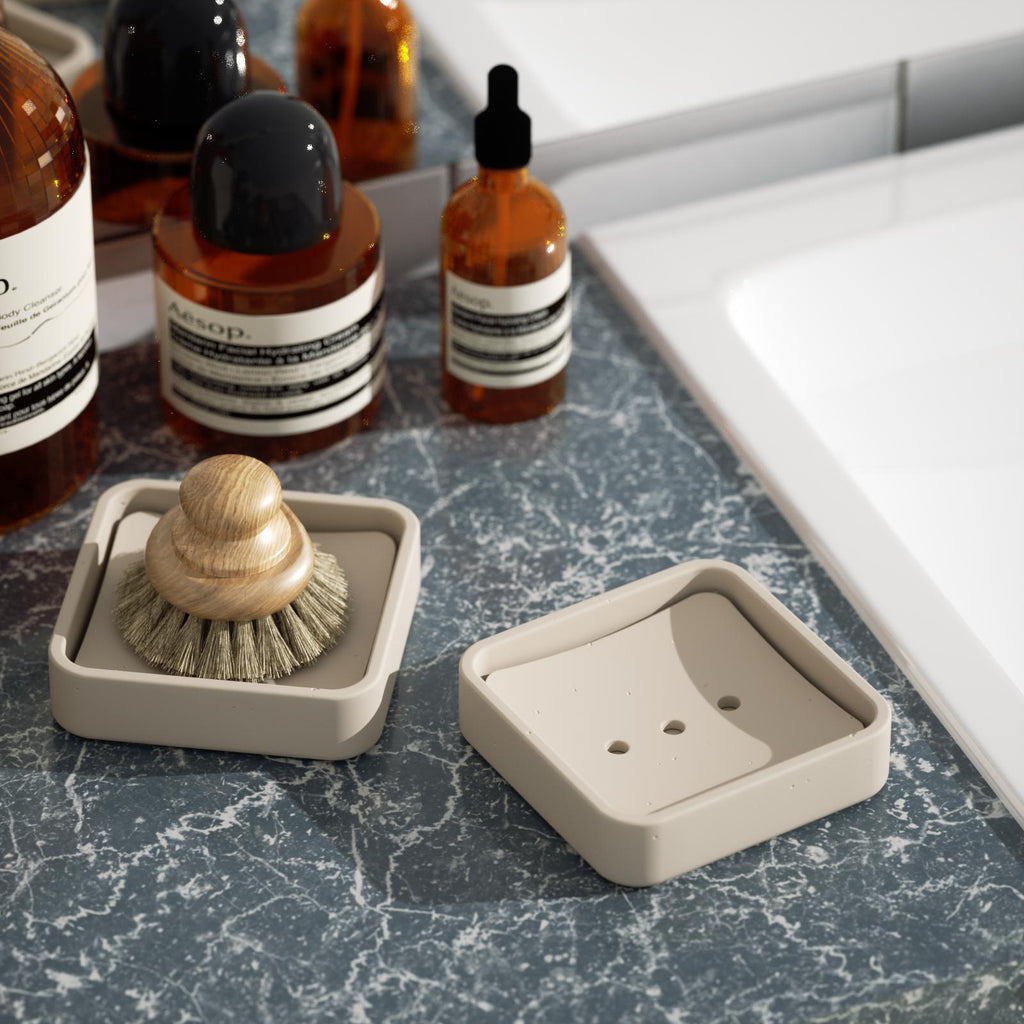 Two gray-brown soap boxes, one containing a shaving brush