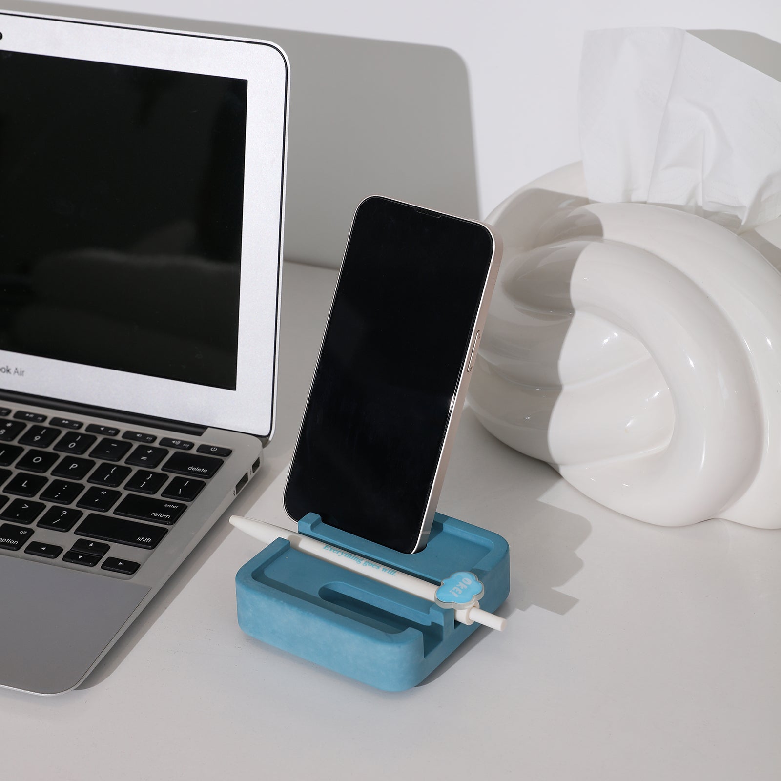 The blue Square Multi-Functional Stationery Support is filled with pens and mobile phones, and there is a laptop next to it - Boowan Nicole