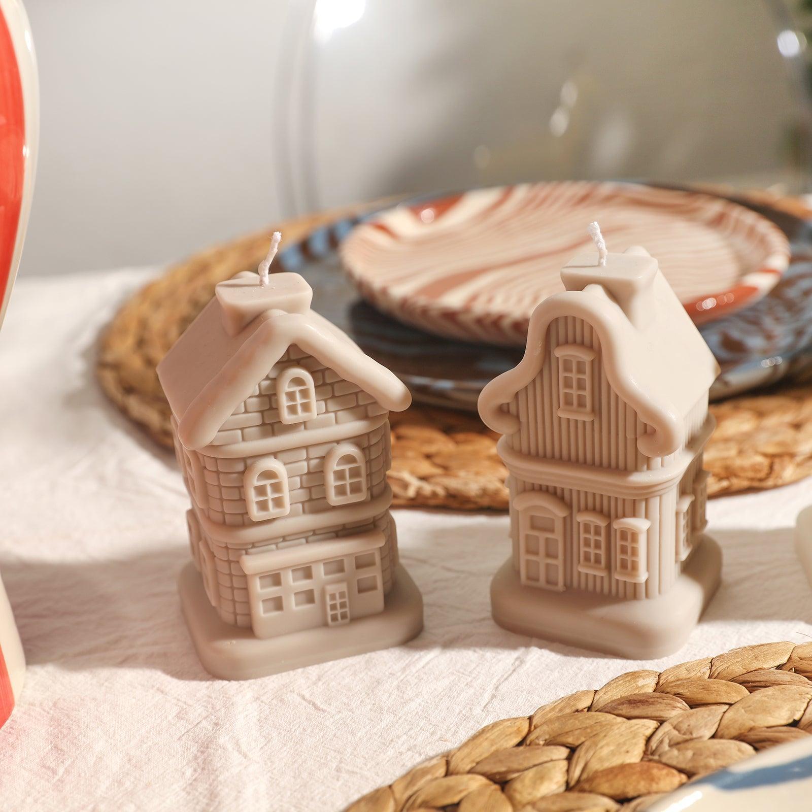 On the table are two house-shaped candles designed by Boowan Nicole.