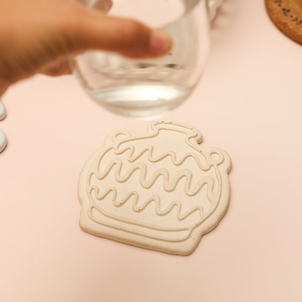 Pick up the water glass from the pale pink coaster, designed by Boowan Nicole.