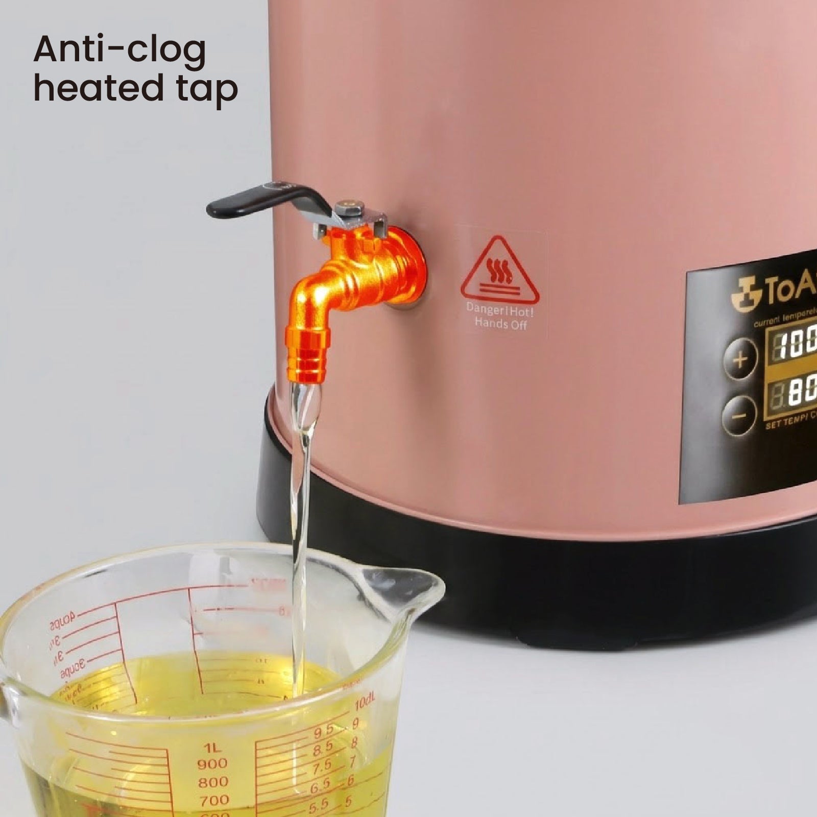 Heated anti-clog tap closeup, melted wax continuously flowing from insulated spout of pink candle wax melting bucket preventing wax solidification blockage - Boowan Nicole