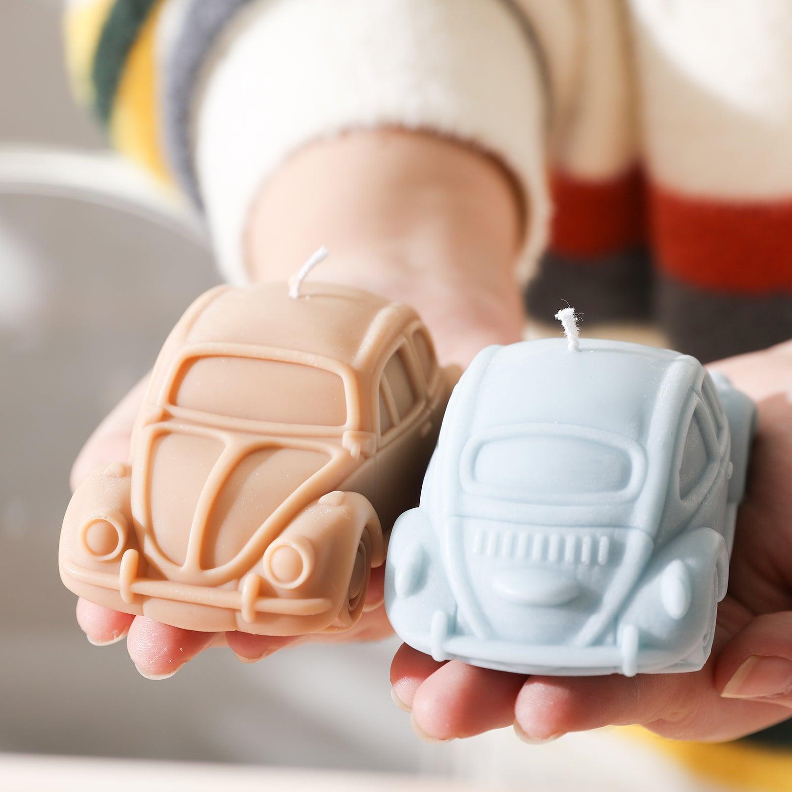 Orange and blue car candles held in hand, displaying unique charm.