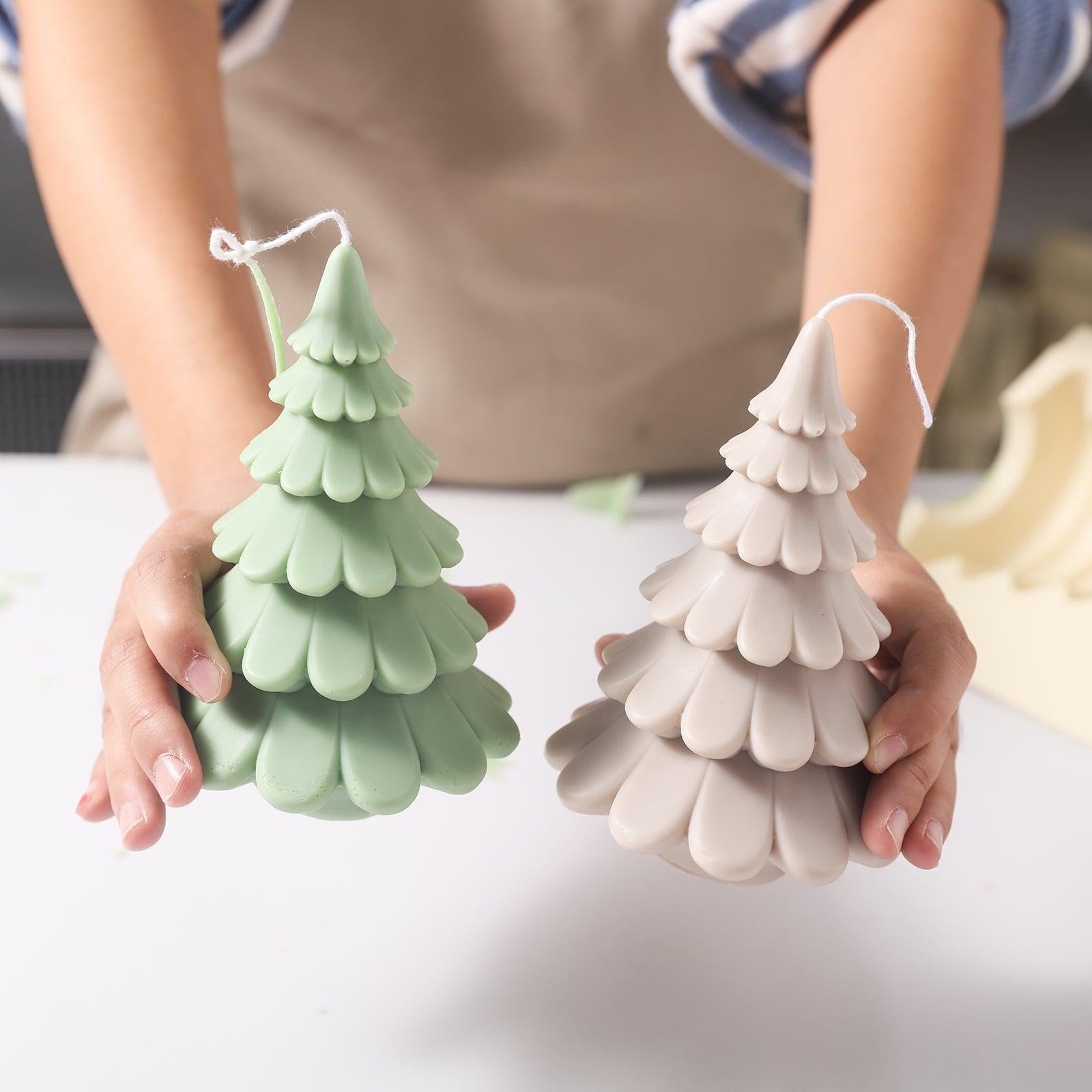 Handheld display of 6-inch green and off-white Christmas tree candles by Boowan Nicole.