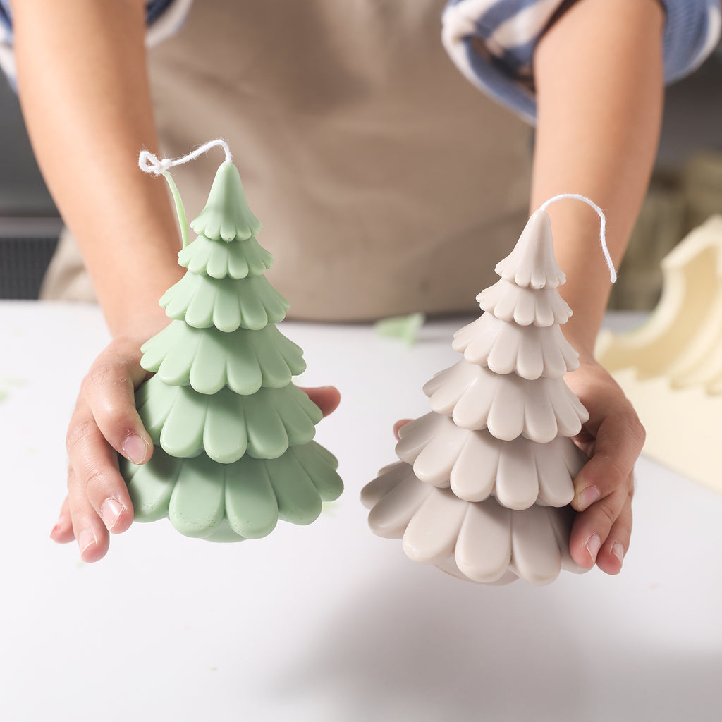 Handheld display of 6-inch green and off-white Christmas tree candles by Boowan Nicole.