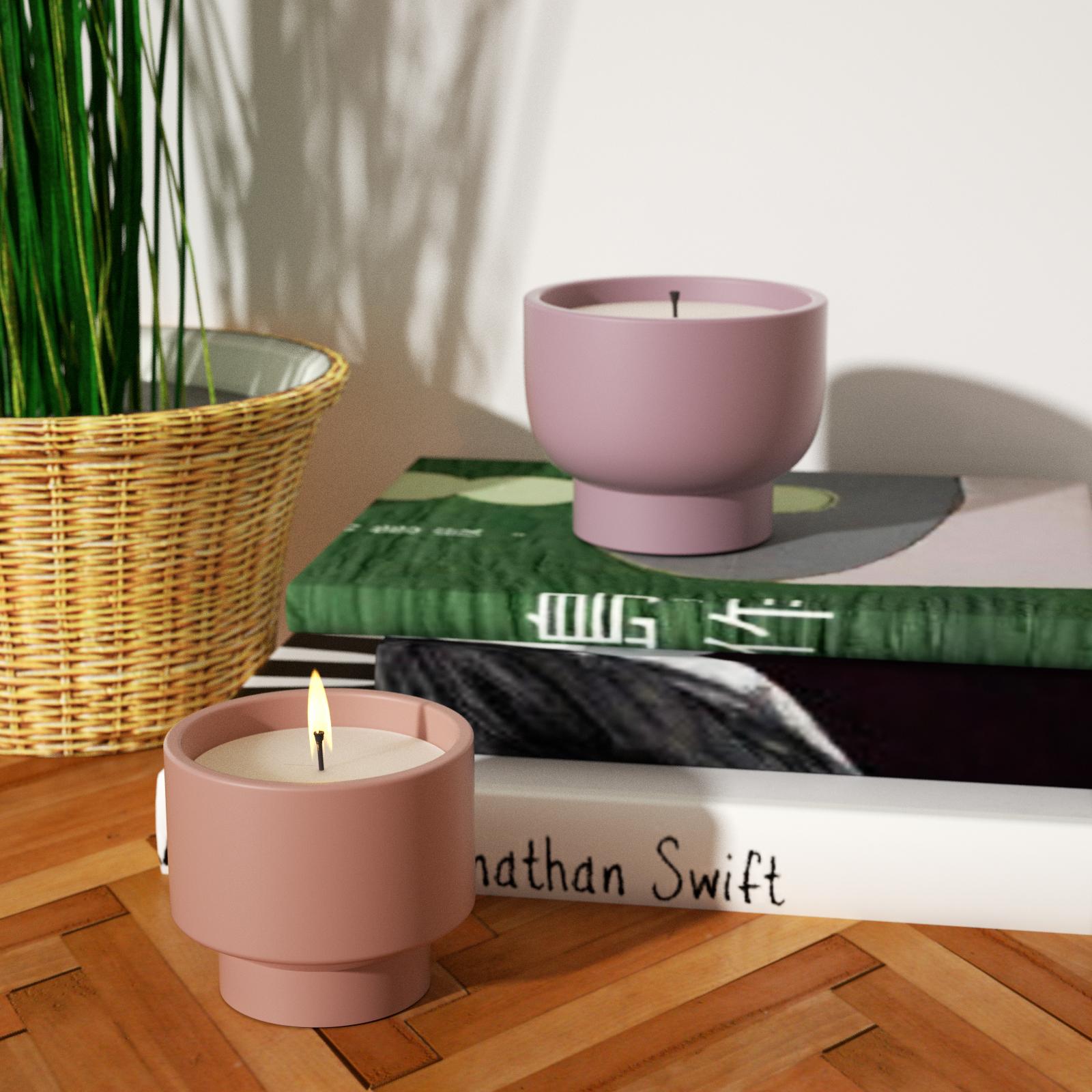  Two boowannicole candle jars, one on the tabletop, the other placed on top of two books. 