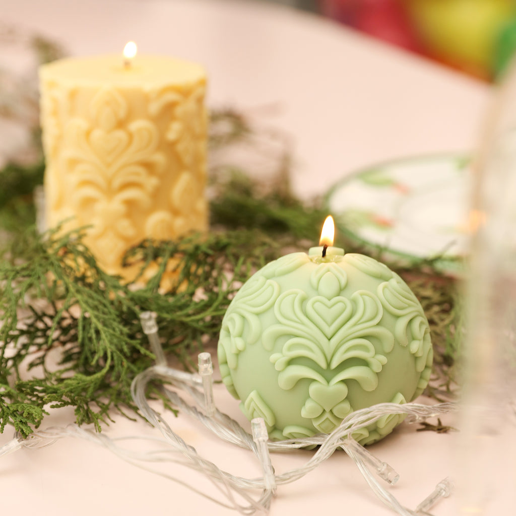 The long and spherical relief candles being lit have pine boughs at their bases.