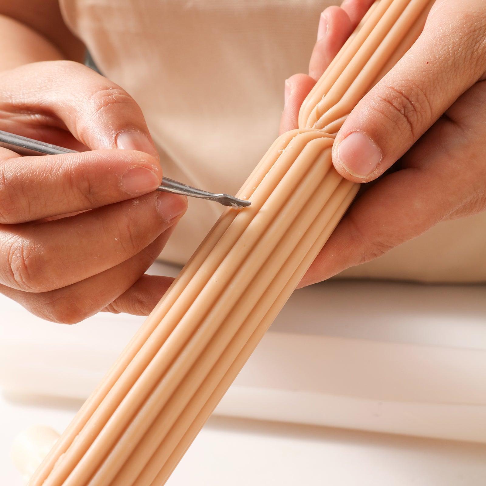 Use tools to trim brown Doric Pillar Taper Candle-Boowan Nicole