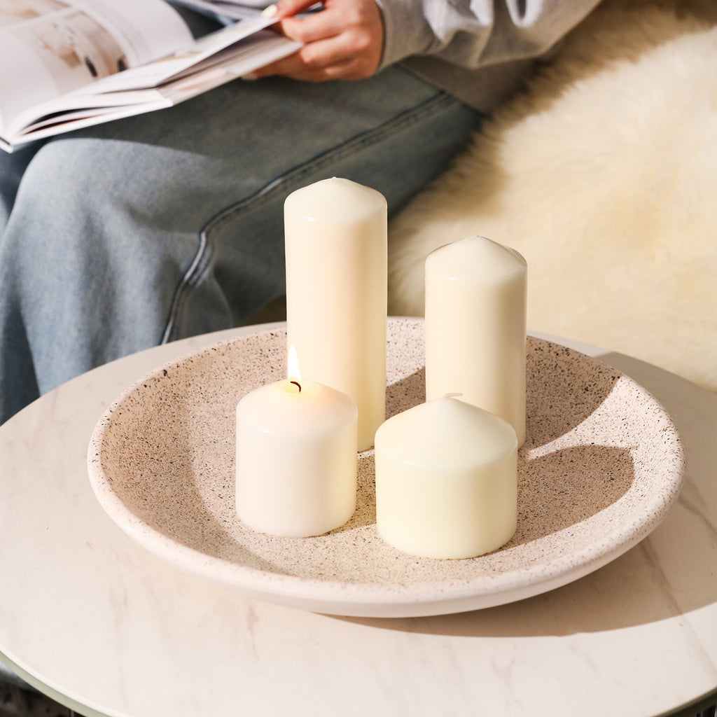 A tray with pillar candles is placed on the coffee table next to the sofa, creating a warm atmosphere.