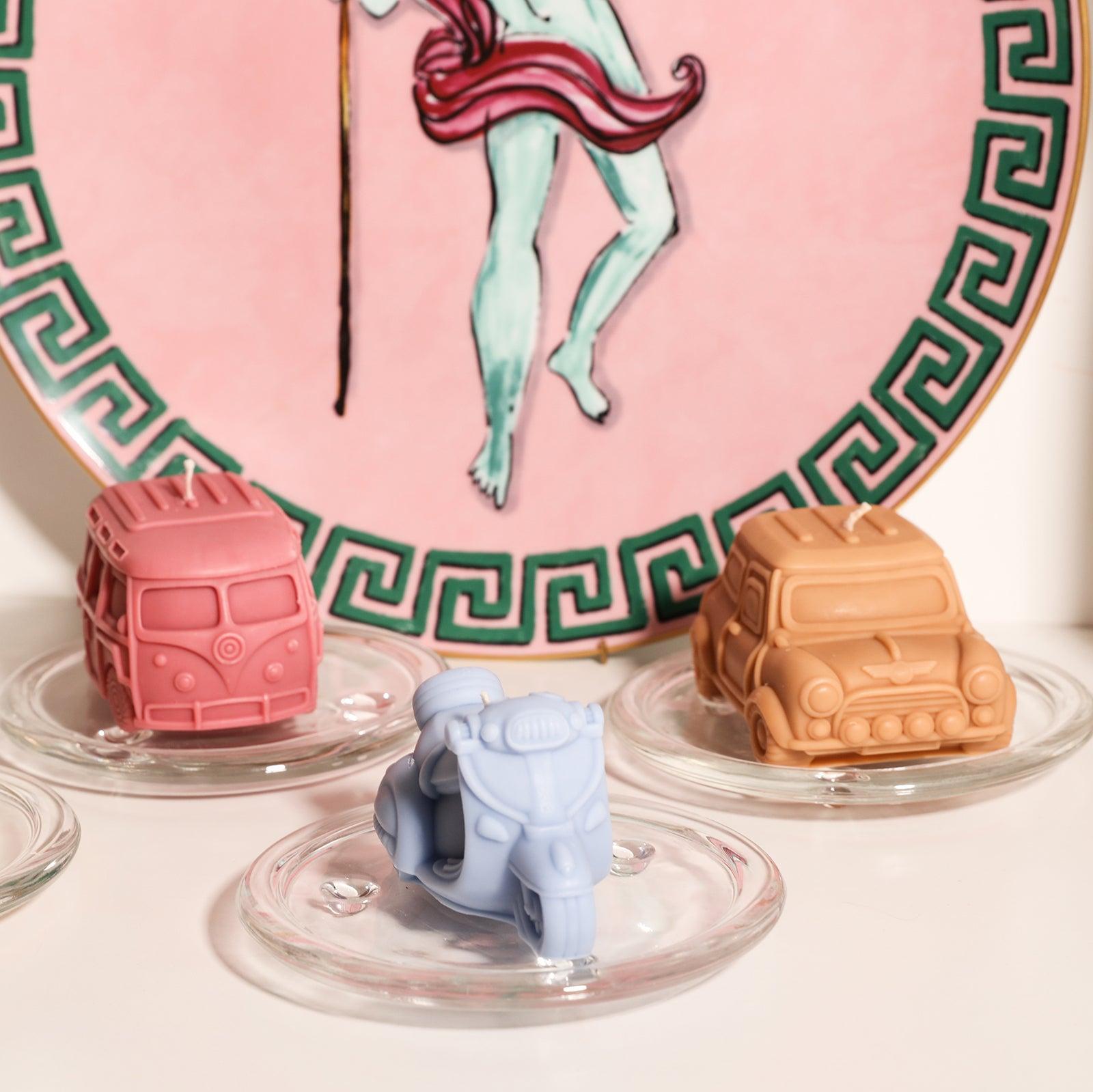 There are red bus, blue motorcycle and brown retro car shaped candles on the crystal tray of the plant stand, designed by Boowan Nicole.