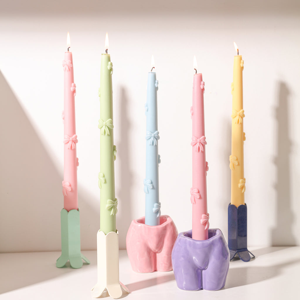 Illuminate the surroundings with the radiant glow of Ribbon Bow Taper Candles in a spectrum of colors, each featuring a delightful bow.