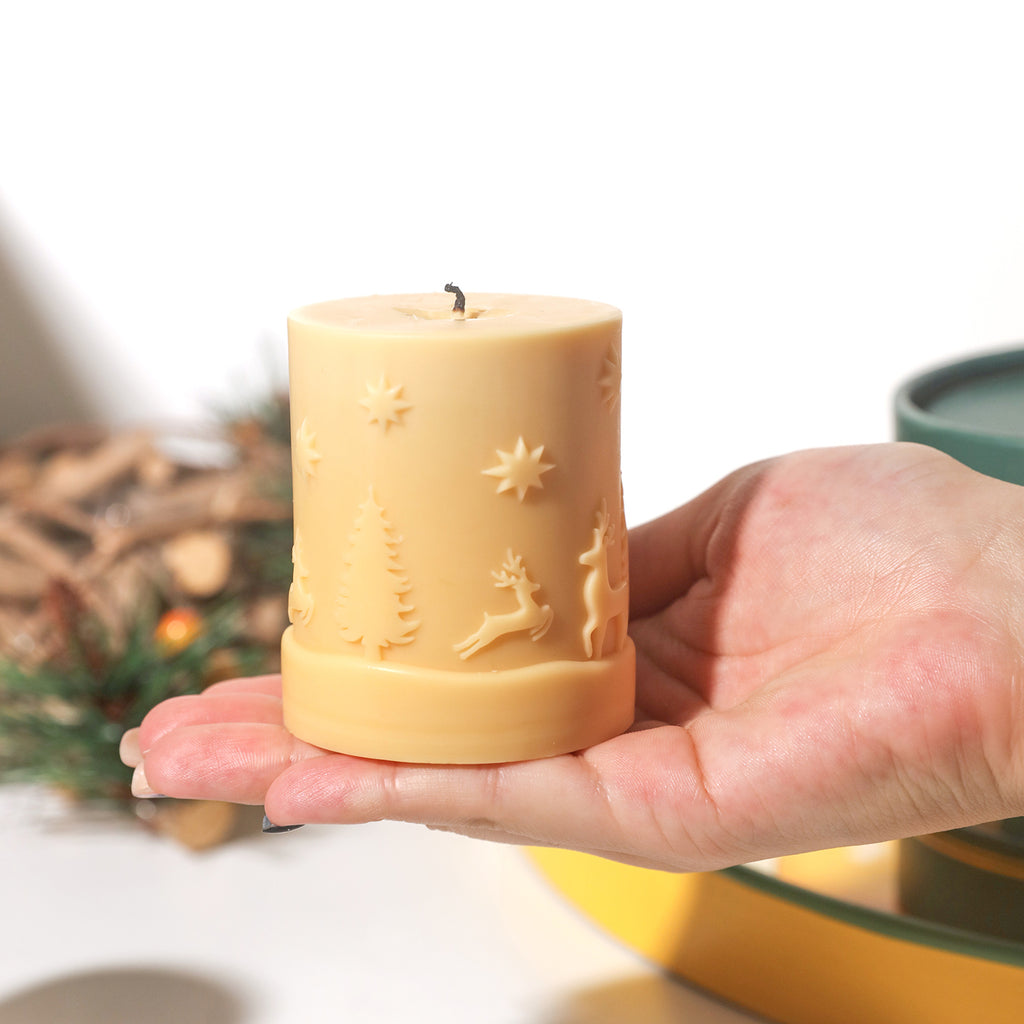 The hand holds a yellow Christmas pattern candle, designed by Boowan Nicole.