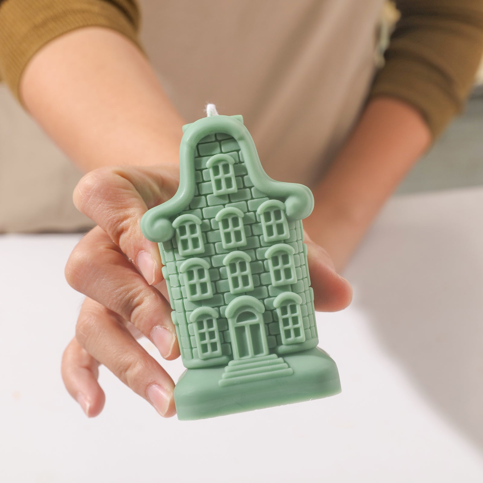 Holding green sweet abode candle display.