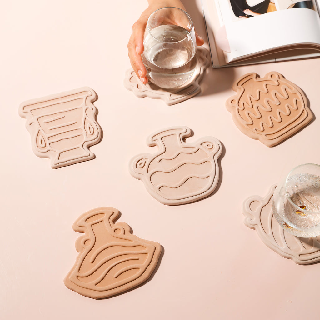Six coasters of different designs are placed on the table, showing practicality while also embodying a sense of decoration, designed by Boowan Nicole.