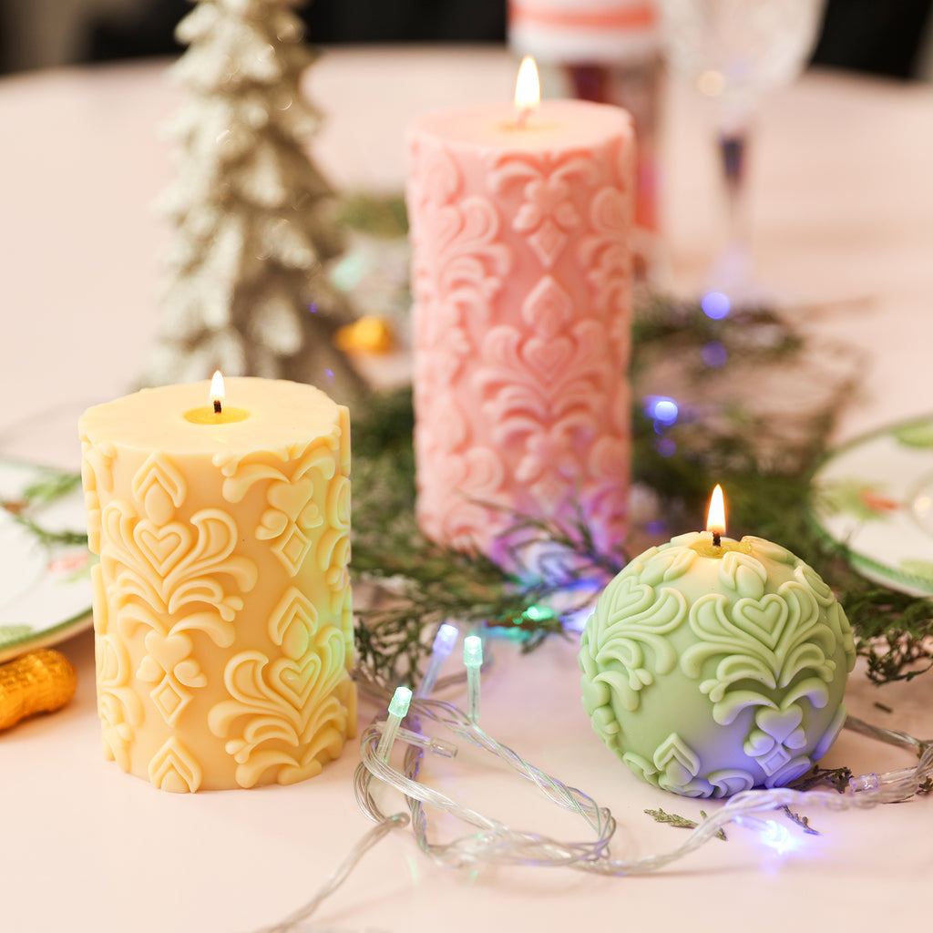 Green ball candle, short orange pillar candle, and long pink pillar candle all lit, showcasing a rich color palette.