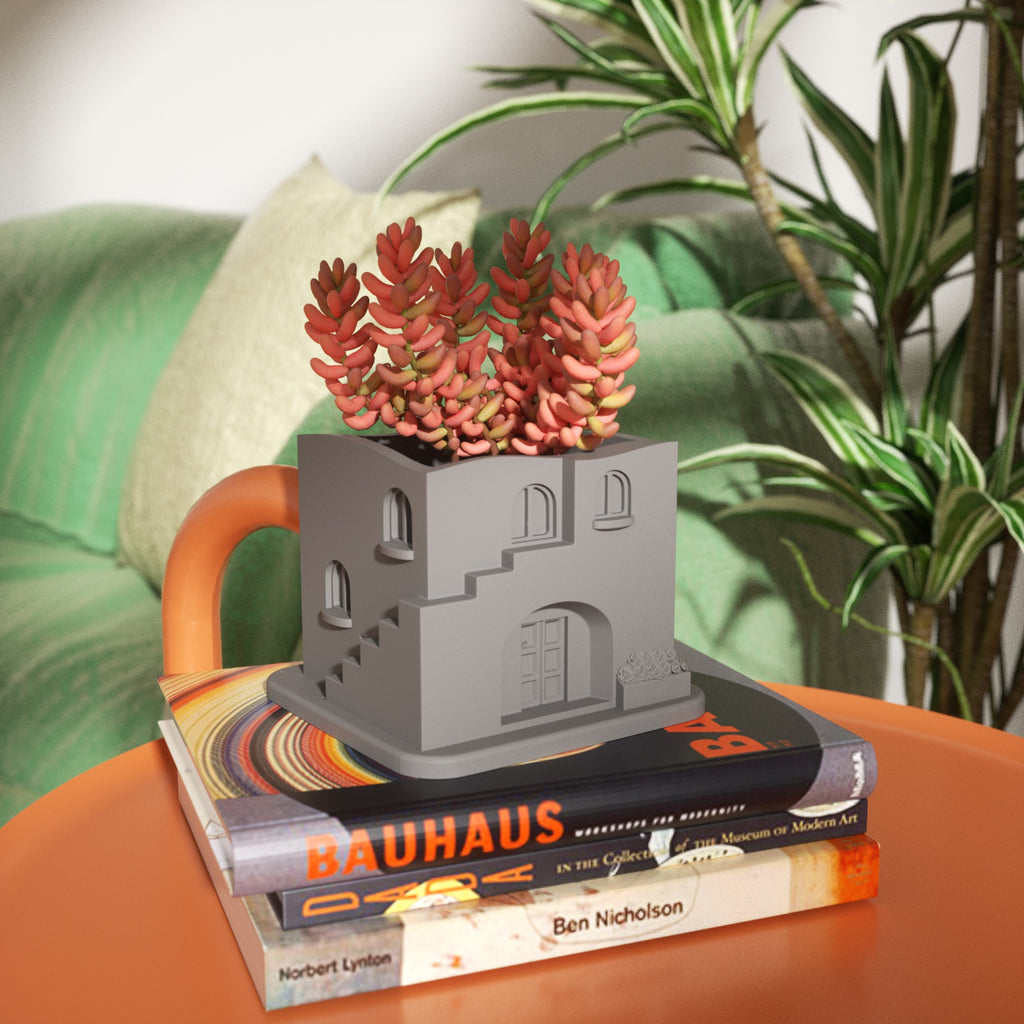 The gray Aegean Santorini House Plant Pot with plants is placed on the book.